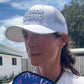 woman wearing a white pickleball hat that says kitchen's closed
