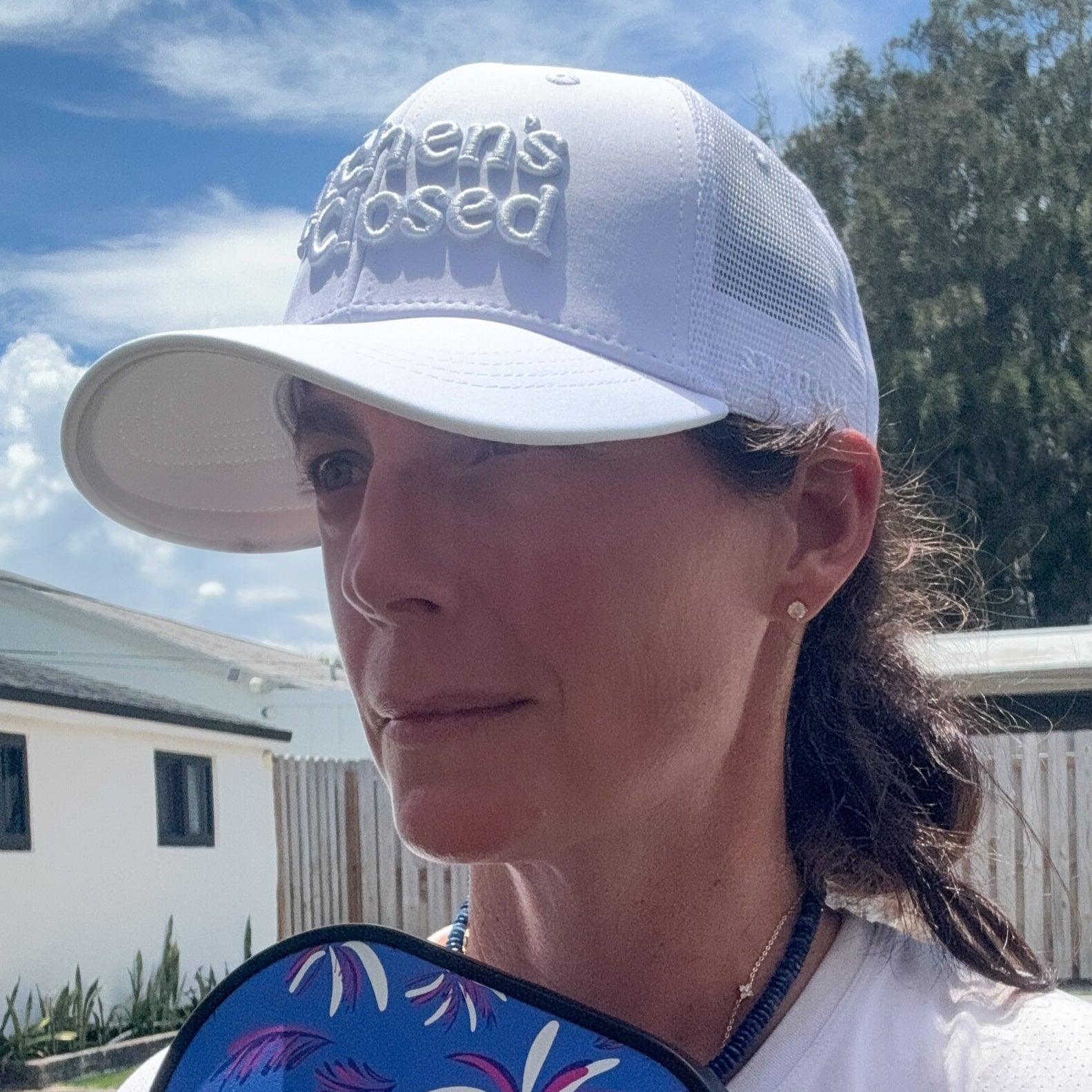 woman wearing a white pickleball hat that says kitchen's closed